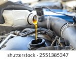 Man pouring motor oil into car engine, closeup