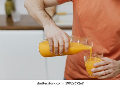 Man Pouring Orange Juice Into A Glass