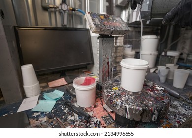 Man Pouring Paint Into White Container On Scale