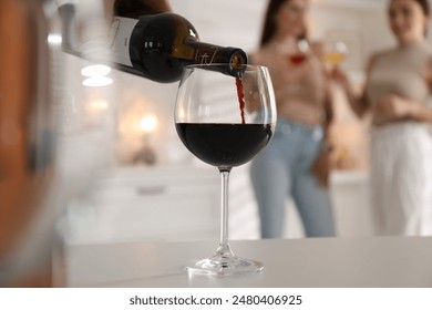 Man pouring red wine into glass at white table, selective focus - Powered by Shutterstock