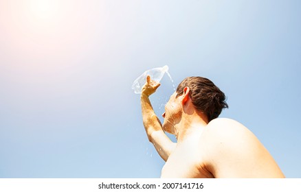 Man Pouring Water From Plastic Bottle On His Head In Hot Day