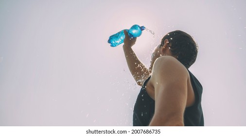 Man Pouring Water From Plastic Bottle On His Head In Hot Day