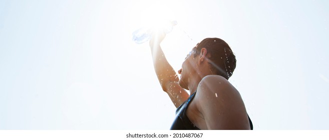 Man Pouring Water From Plastic Bottle On His Head In Hot Day