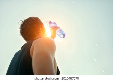 Man Pouring Water From Plastic Bottle On His Head In Hot Day