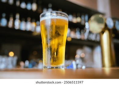 A man pours frothy beer into a glass at a lively pub. Friends gather around the bar, enjoying drinks and celebrating, with a warm, golden glow highlighting the joyful, friendly atmosphere. - Powered by Shutterstock