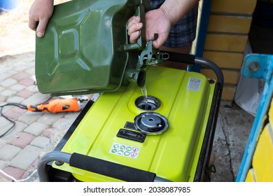 A man pours gasoline into a generator on the doorstep. - Shutterstock ID 2038087985