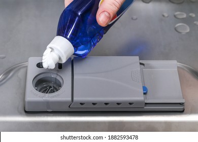 A Man Pours A Rinse Aid Into The Dishwasher Compartment.