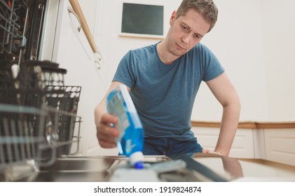 Man Pours Rinse Aid Into The Dishwasher Compartment.