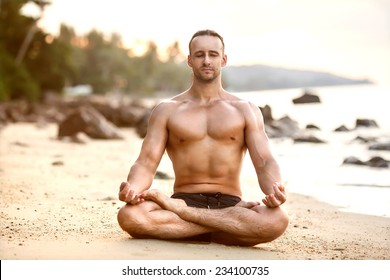 Man Practice Yoga On The Beach At Sunset 