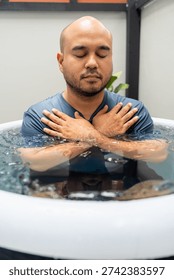 Man practices cold therapy and ice bathing in inflatable tub, using Wim Hof Method for wellness, meditation, fitness recovery, sports therapy. Wellness and healthy lifestyle.