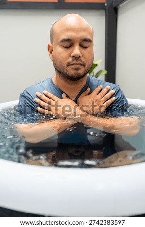 Man practices cold therapy and ice bathing in inflatable tub, using Wim Hof Method for wellness, meditation, fitness recovery, sports therapy. Wellness and healthy lifestyle.