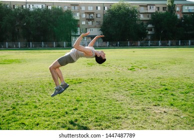 Man Practices Parkour And Free Running By Doing A Backflip At The Stadium