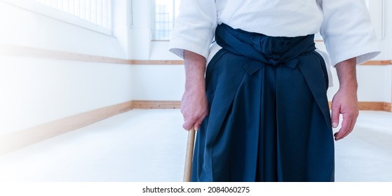 Man Practicing Aikido Martial Art In A Dojo Background.