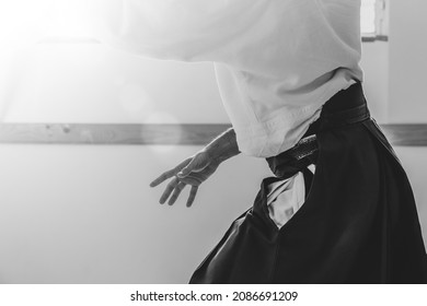 Man Practicing Aikido Martial Art In A Dojo Background With Backlight.