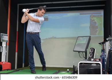 Man Practicing Golf Swing Using Simulator