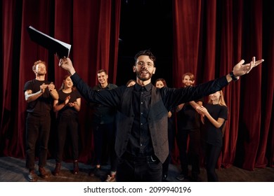 Man is practicing his role. Group of actors in dark colored clothes on rehearsal in the theater. - Shutterstock ID 2099940196