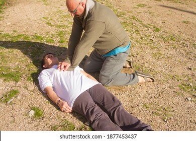 man practicing resuscitation to a woman with heart massage and mouth to mouth 
