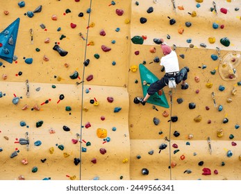 Man practicing Rock climbing wall bouldering Indoor Active lifestyle - Powered by Shutterstock