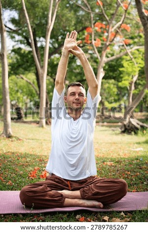 Man practicing yoga exercise and flexibility training outdoors in natural park environment for healthy lifestyle wellness fitness and mindfulness balance.