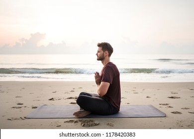 Man practicing yoga on the beach - Powered by Shutterstock