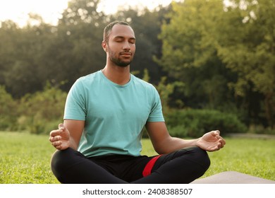 Man practicing yoga on mat outdoors. Lotus pose - Powered by Shutterstock