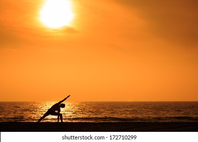 Man Practicing Yoga On Ocean Beach