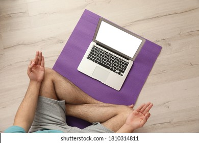 Man practicing yoga while watching online class at home during coronavirus pandemic, top view. Social distancing