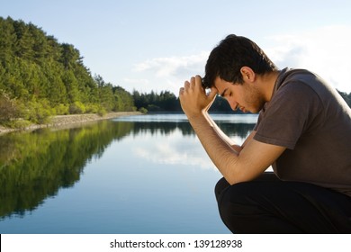 Man praying by lake