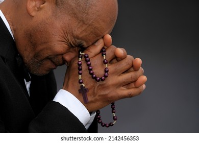 man praying to god with hands together on grey background stock photo 
