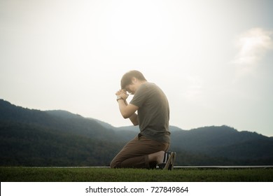 A man is praying to God on the mountain.