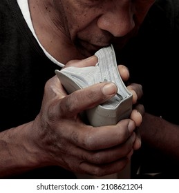 Man Praying With Hand On Bible With Black Background Stock Photo