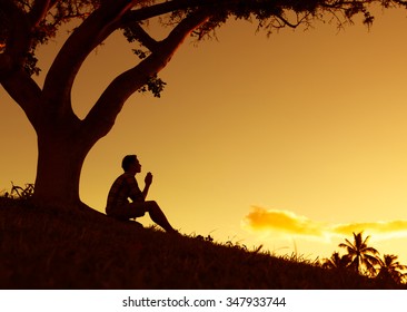 Man Praying, Meditating In Harmony And Peace At Sunset