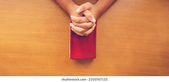 Man praying on holy bible with wooden block word bible.Worship Faith and Read Bible Online at home.Bible study in home church, wisdom of GOD, Holy spirituality , Worship and Christian.Prayer pray. - Shutterstock ID 2310767133