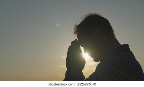 man praying at sunset, asking heaven for help and support, spiritual man contemplating, the concept of faith and hope, reflections in the rays of sunlight, trustworthy religion