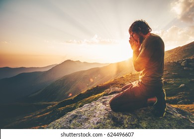 Man praying at sunset mountains Travel Lifestyle spiritual relaxation emotional meditating concept vacations outdoor harmony with nature landscape