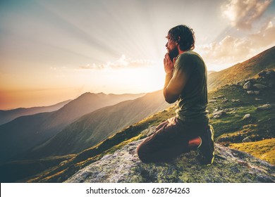 Man praying at sunset mountains Travel Lifestyle spiritual relaxation emotional concept vacations outdoor harmony with nature landscape - Shutterstock ID 628764263