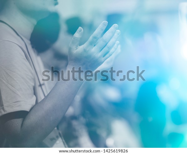 Man praying and worship to\
GOD in Church.Man raised hands and pray to GOD.Hand praying and\
palmup,Concept Praise and worship with faith, spirituality and\
Surrender.