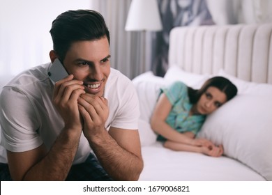 Man preferring talking on phone over spending time with his girlfriend at home. Jealousy in relationship
