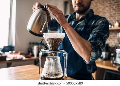 Man prepares coffee in style "pour over" and hario in barista school. - Shutterstock ID 593887583