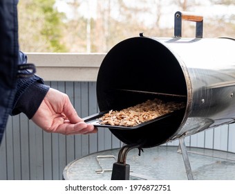 A Man Prepares Food, Wood Shavings For An Electric Smokehouse.