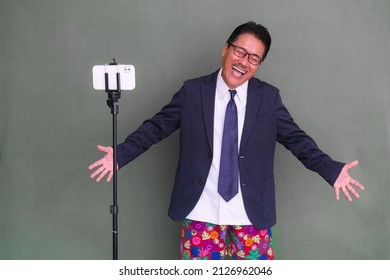 A Man Prepares Himself To Give Online Training From Home. He Was Laughing Realizing That He Neatly Dressed In A Suit But Still Wearing Colorful Boxer Shorts.