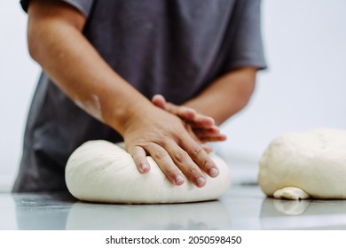 Man preparing bread dough on table in a bakery factory.Dough ball for croissant bakery.pizza, bakery bread.Chef homemade bakery with hand.baker man make fresh dough prepare in kitchen.food pastry. - Powered by Shutterstock