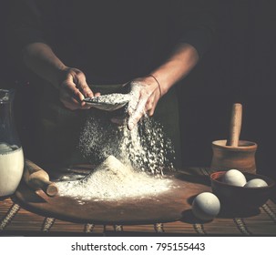 Man preparing bread dough on wooden table in a bakery close up. Preparation of Easter bread.