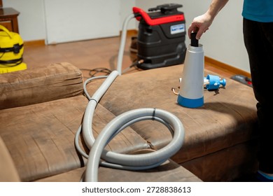 Man preparing cleaning solution before washing upholstered furniture. Professional sofa cleaning process, upholstery care, cleaning services and home interior maintenance.
