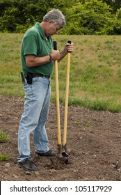 Man Preparing To Erect A Fence By Digging A Post Hole