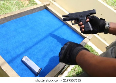 A Man To Preparing Gun At Training Shooter School. 9mm Automatic Pistol Gun Holding In Hand Of Gun Shooter, Training By Using Pistol Gun To Save And To Protect