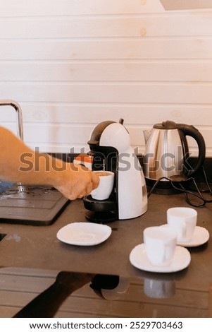 Man preparing morning coffee using a coffee machine, creating a cozy atmosphere at home