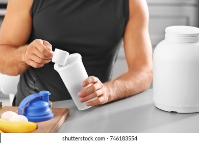 Man Preparing Protein Shake In Kitchen