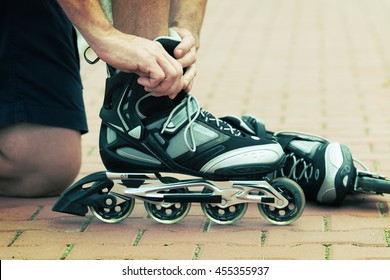 Man Preparing For Roller Blading, Putting On Rollerblades.