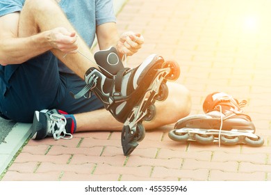 Man Preparing For Roller Blading, Putting On Rollerblades.